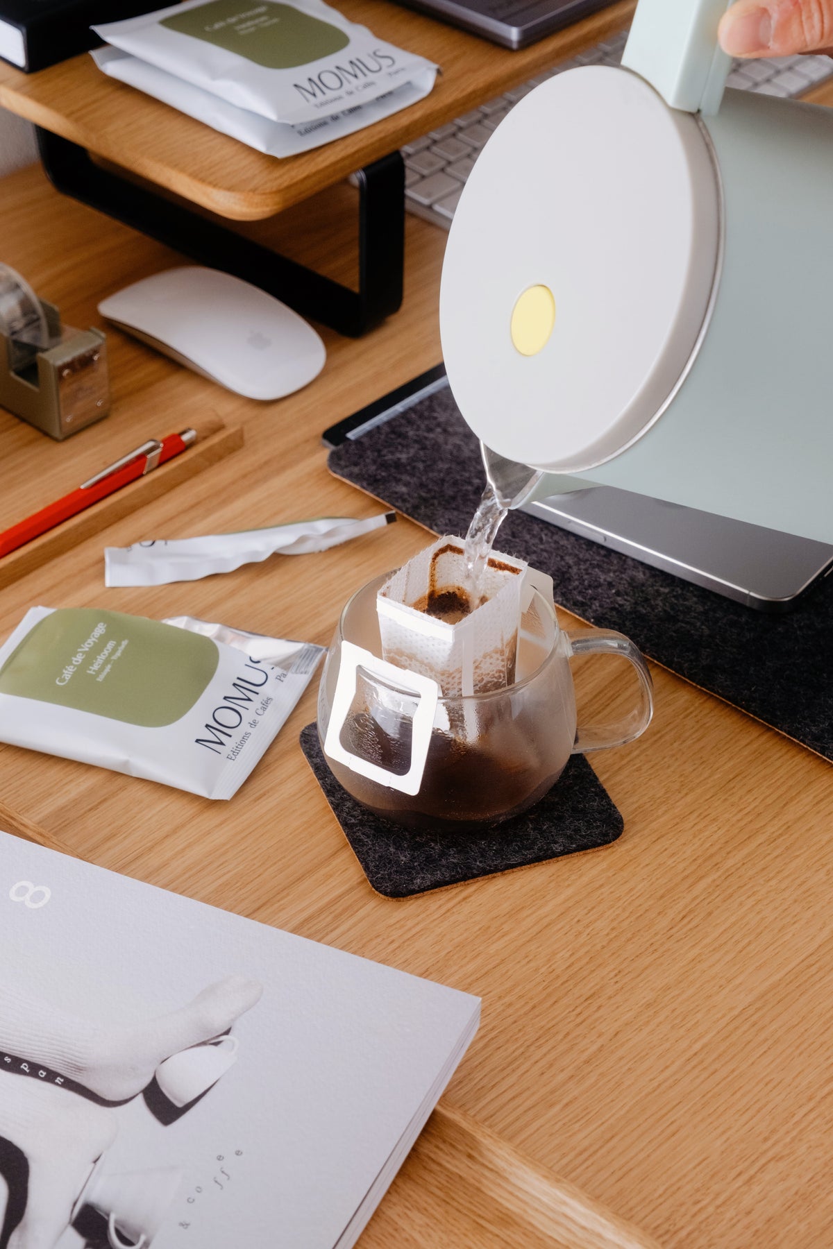 Une bouilloire, l'eau chaude versé dans la tasse où il y a un Drip Bags