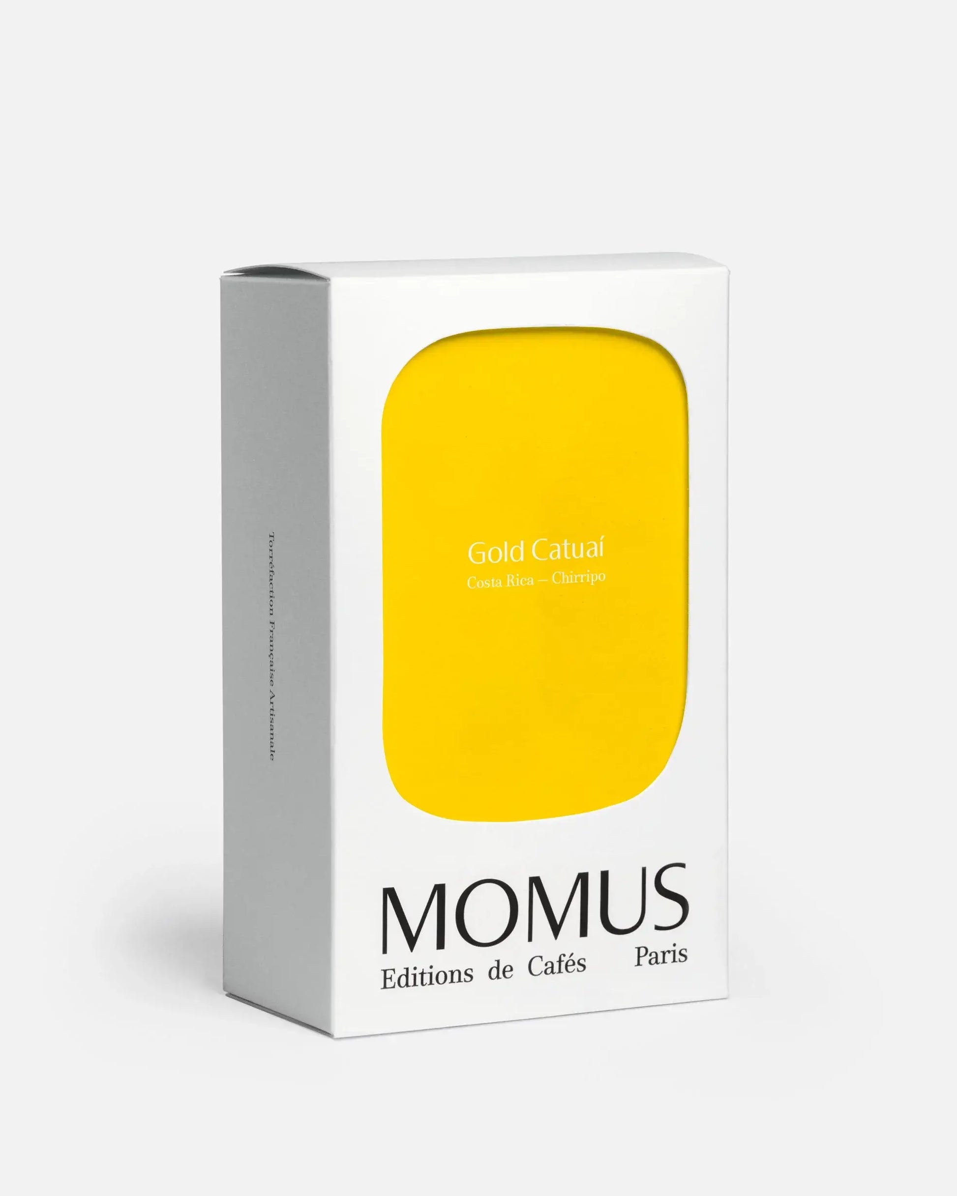 Packaging du café Gold Catuaí de Momus, éditions de cafés, avec façade jaune minimaliste.
