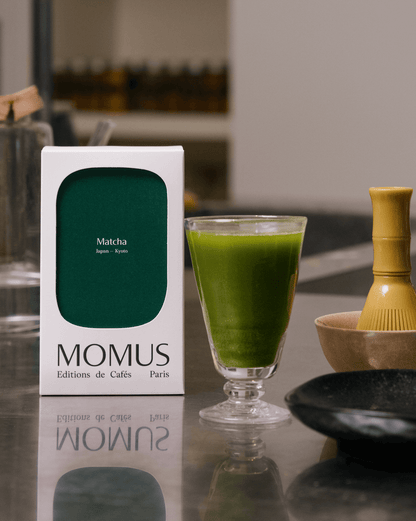 Un verre contenant du thé matcha, pour avec  l'emballage Momus au couleur vert