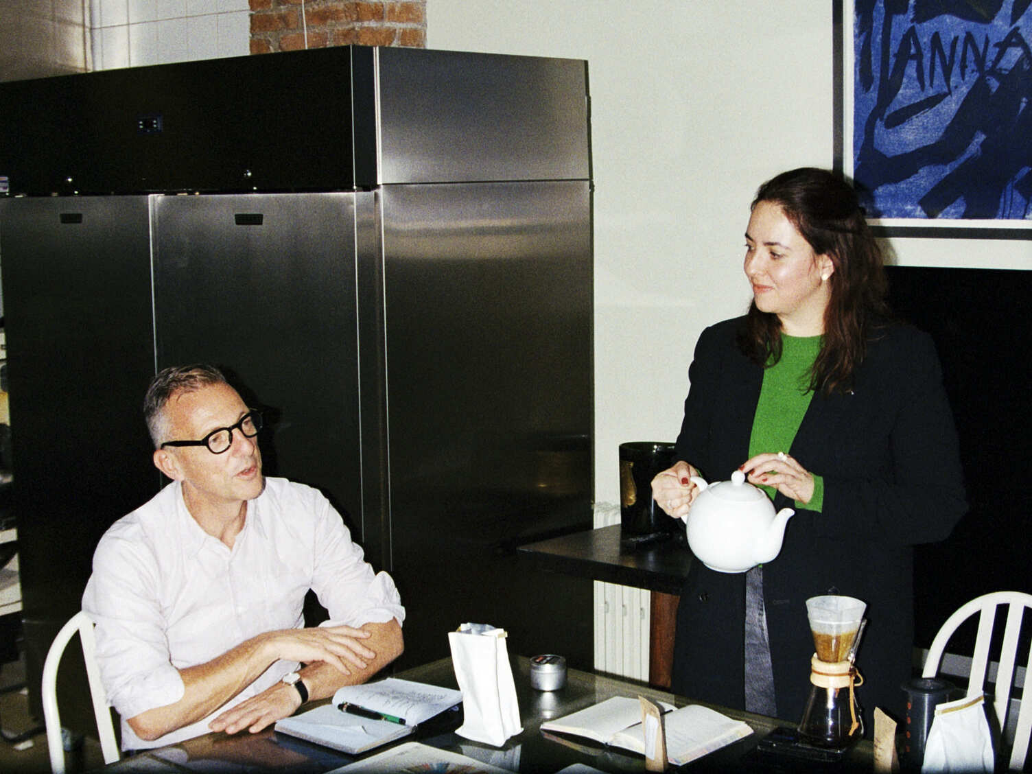 Un café avec Olivier Saillard en entretien avec Daniela Capuano qui tient un théière avec laquelle elle verse de l'eau dans une cafetière à filtre