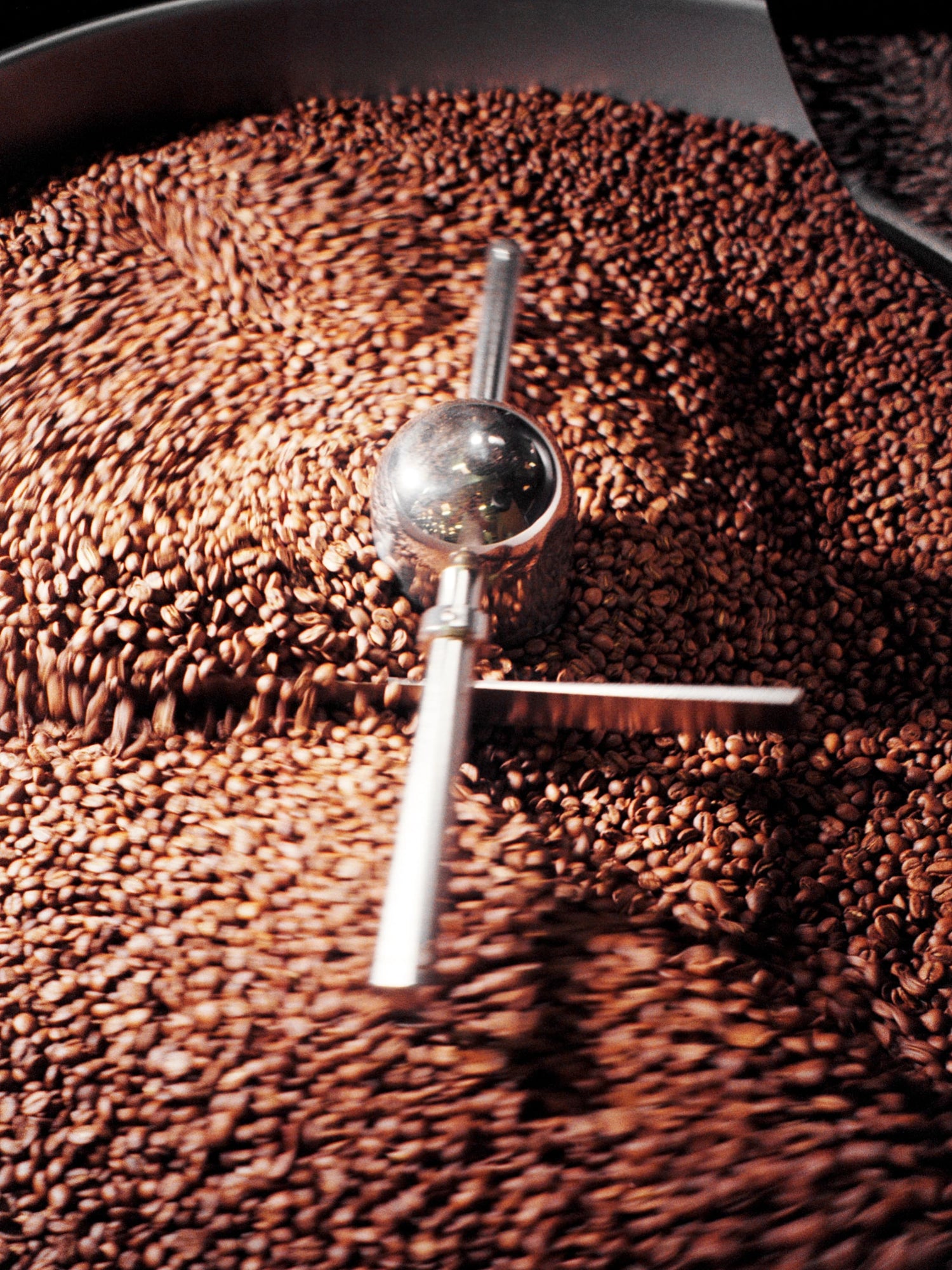 Grains de café en train de tourner dans un torréfacteur industriel.