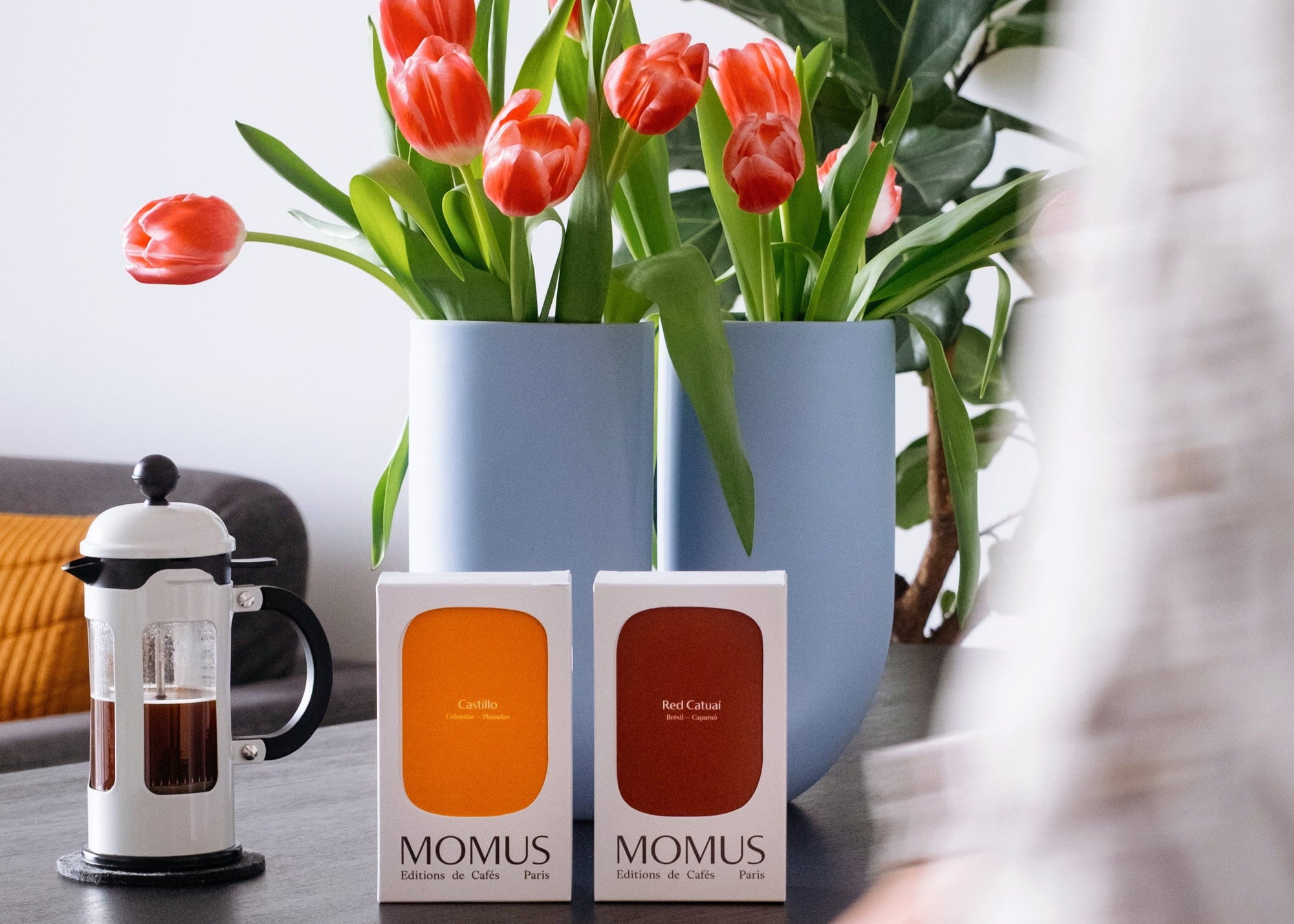 Coffrets de café d'exception Momus Paris avec fleurs printanières et cafetière à piston pour une idée cadeau de Saint-Valentin.